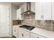 Modern kitchen showcasing a stainless steel range hood, white cabinets, and a gas cooktop at 32611 N 20Th Dr, Phoenix, AZ 85085