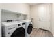 This laundry room has a new washer/dryer set and white plank flooring at 32611 N 20Th Dr, Phoenix, AZ 85085