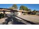 Tan single-story home featuring a two-car garage, a front yard with desert landscaping, and a concrete driveway at 3323 N 103Rd Ave, Avondale, AZ 85392