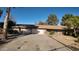 Tan single-story house featuring a two-car garage, a desert-style front yard, and a concrete driveway at 3323 N 103Rd Ave, Avondale, AZ 85392