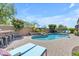 Luxurious backyard pool area with ample seating, lush landscaping, and a built-in bar at 35701 N Bandolier Dr, San Tan Valley, AZ 85144