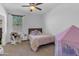 Bedroom with neutral walls, ceiling fan, and bed with pink zebra striped blanket at 35701 N Bandolier Dr, San Tan Valley, AZ 85144