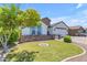 Inviting single-story home boasts a manicured lawn, stone veneer accents, and an attached two-car garage at 35701 N Bandolier Dr, San Tan Valley, AZ 85144