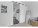 View of a hallway through an open sliding barn door, highlighting the sleek flooring and bright interior design at 35701 N Bandolier Dr, San Tan Valley, AZ 85144