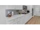 Elegant kitchen features white cabinets, quartz countertops, and modern backsplash at 35701 N Bandolier Dr, San Tan Valley, AZ 85144