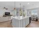 Bright open-concept kitchen featuring an island, quartz countertops, and modern lighting at 35701 N Bandolier Dr, San Tan Valley, AZ 85144
