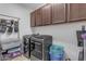 Well-equipped laundry room with modern washer, dryer and ample storage cabinets at 35701 N Bandolier Dr, San Tan Valley, AZ 85144