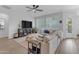 Inviting living room features a comfortable sectional sofa, ceiling fan, and seamless indoor-outdoor flow to a pool area at 35701 N Bandolier Dr, San Tan Valley, AZ 85144