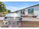 Stainless steel outdoor grill with tile countertop, perfect for summer barbecues and outdoor entertaining by the pool at 35701 N Bandolier Dr, San Tan Valley, AZ 85144