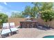 Inviting outdoor kitchen with stone bar, seating, brick patio, and privacy wall creates the perfect space for entertaining at 35701 N Bandolier Dr, San Tan Valley, AZ 85144