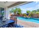 Beautiful pool area with a rock waterfall feature, outdoor kitchen, lush landscaping, and covered patio at 35701 N Bandolier Dr, San Tan Valley, AZ 85144