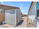 Exterior shot of a well-maintained storage shed on a brick pathway, nestled between two homes at 35701 N Bandolier Dr, San Tan Valley, AZ 85144