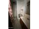 Bathroom area featuring a shower with curtain, toilet, vanity and cabinet for extra storage at 3701 W Keim Dr, Phoenix, AZ 85019