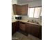 Features stainless steel double sink, wooden cabinets, and window with natural light to the kitchen at 3701 W Keim Dr, Phoenix, AZ 85019