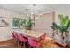 Elegant dining room featuring hardwood floors, a rustic table, exposed brick wall, and stylish light fixture at 4036 N 40Th Pl, Phoenix, AZ 85018