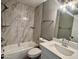 Modern bathroom with tub, shower, and vanity with new fixtures and tiled walls at 4104 N 113Th Ave, Phoenix, AZ 85037