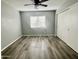 Clean bedroom featuring wood-look floors, a window with blinds, and a sliding-door closet at 4104 N 113Th Ave, Phoenix, AZ 85037