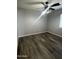 A room with hardwood floors, a window, a ceiling fan with a light fixture, and neutral paint at 4104 N 113Th Ave, Phoenix, AZ 85037