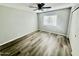 Bright bedroom featuring wood-style flooring, a window, and a ceiling fan with lighting at 4104 N 113Th Ave, Phoenix, AZ 85037