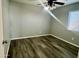 A room with hardwood floors, a window, and a ceiling fan with a light fixture, and neutral paint at 4104 N 113Th Ave, Phoenix, AZ 85037