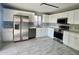 Modern kitchen with stainless steel appliances, white cabinets, and gray tile floors at 4104 N 113Th Ave, Phoenix, AZ 85037