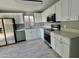 Well-lit kitchen featuring white cabinets, stainless steel appliances, and gray tile flooring at 4104 N 113Th Ave, Phoenix, AZ 85037