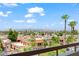 A scenic view from a balcony shows a neighborhood, trees, and a mountain range in the distance at 4200 N Miller Rd # 504, Scottsdale, AZ 85251