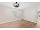 Unfurnished bedroom featuring wood-look floors, a ceiling fan and a large window with shutters at 4200 N Miller Rd # 504, Scottsdale, AZ 85251