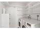 Functional laundry room with washer, dryer, built-in shelving and convenient storage options at 4200 N Miller Rd # 504, Scottsdale, AZ 85251