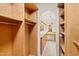 Open walk-in closet with custom shelving and an arched entryway to the bathroom at 4200 N Miller Rd # 504, Scottsdale, AZ 85251