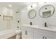 Stylish bathroom featuring double vanity with modern fixtures and a tiled shower with tub at 4701 N 63Rd Dr, Phoenix, AZ 85033