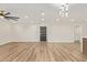 Bright living room features light wood flooring, ceiling fan, and modern lighting fixture at 4701 N 63Rd Dr, Phoenix, AZ 85033