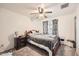 Comfortable bedroom with a dark wood bed frame, carpeting and a ceiling fan with dark accents at 5343 W Coronado Rd, Phoenix, AZ 85035