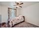 Cozy bedroom with carpet, a decorative ceiling fan, and a light-colored comforter at 5343 W Coronado Rd, Phoenix, AZ 85035