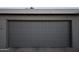 Gray garage door with decorative squares and a textured stucco wall above at 8848 N New World Dr, Glendale, AZ 85302
