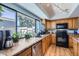 Updated kitchen with stainless steel appliances, wood cabinets, granite countertops, and a large window overlooking the yard at 8848 N New World Dr, Glendale, AZ 85302