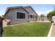 Well-maintained backyard with green lawn, desert landscaping and a view of the home's exterior at 10165 E Gamma Ave, Mesa, AZ 85212