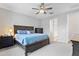 Cozy bedroom boasts a ceiling fan, dark wood furniture, and neutral carpet complemented by blue accents at 10165 E Gamma Ave, Mesa, AZ 85212
