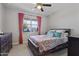 Cozy bedroom with a ceiling fan, a large window, and comfortable carpet flooring at 10165 E Gamma Ave, Mesa, AZ 85212