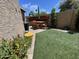 Charming backyard with artificial turf, a patio dining set, and colorful flower beds for outdoor relaxation at 12421 N 41St Pl, Phoenix, AZ 85032