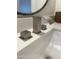 Modern sink with a waterfall faucet with a white countertop and black rimmed mirror at 12421 N 41St Pl, Phoenix, AZ 85032