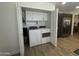 Bright laundry space with stacked washer/dryer, storage cabinets, and modern appliances adjacent to the kitchen at 12421 N 41St Pl, Phoenix, AZ 85032