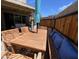 Outdoor patio features a wooden table and bench with blue cushions, shaded by an umbrella at 12421 N 41St Pl, Phoenix, AZ 85032