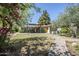 Lush backyard featuring mature trees, a covered patio, and a stone pathway enhancing the outdoor space at 1274 E Edgemont Ave, Phoenix, AZ 85006