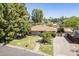 Inviting single-story home with a brick pathway, lush lawn, mature trees, and a brick driveway at 1274 E Edgemont Ave, Phoenix, AZ 85006