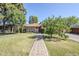 Inviting single-story home with a brick pathway, lush lawn, mature trees, and a brick driveway at 1274 E Edgemont Ave, Phoenix, AZ 85006