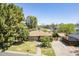 Charming single-story home with a well-manicured lawn, mature trees, and a brick driveway leading to a wooden gate at 1274 E Edgemont Ave, Phoenix, AZ 85006