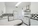 Bright kitchen with plentiful white cabinets and classic black and white tile countertops and backsplash at 1274 E Edgemont Ave, Phoenix, AZ 85006