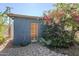 Charming shed surrounded by blooming bougainvillea, featuring a wooden door and brick pavers at 1274 E Edgemont Ave, Phoenix, AZ 85006