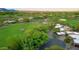 Aerial view of a desert home near a golf course, surrounded by lush greenery and a winding driveway at 1637 N Quartz Valley Rd, Scottsdale, AZ 85266